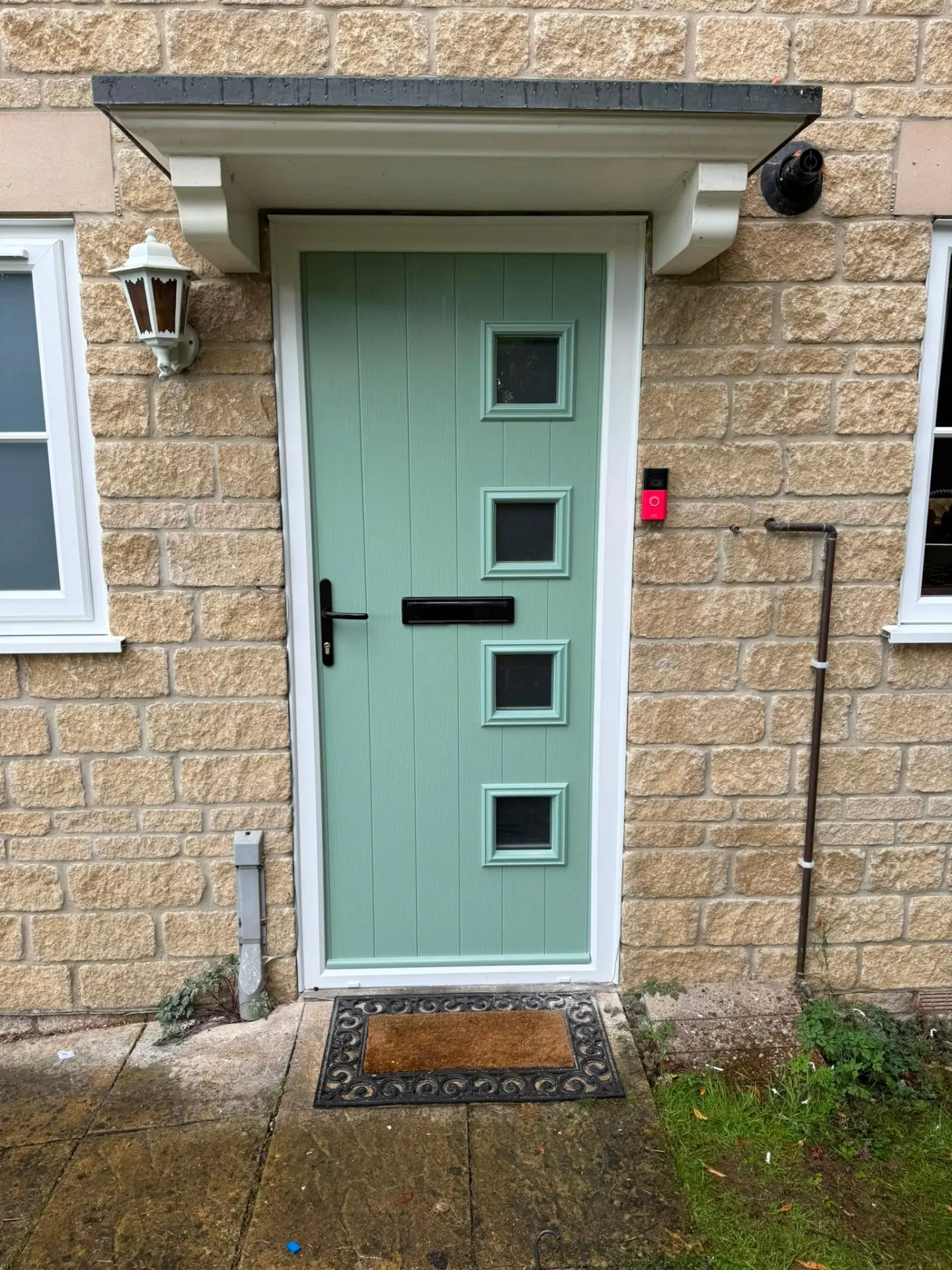 Chartwell green composite door with four square windows fitted to a stone-built home