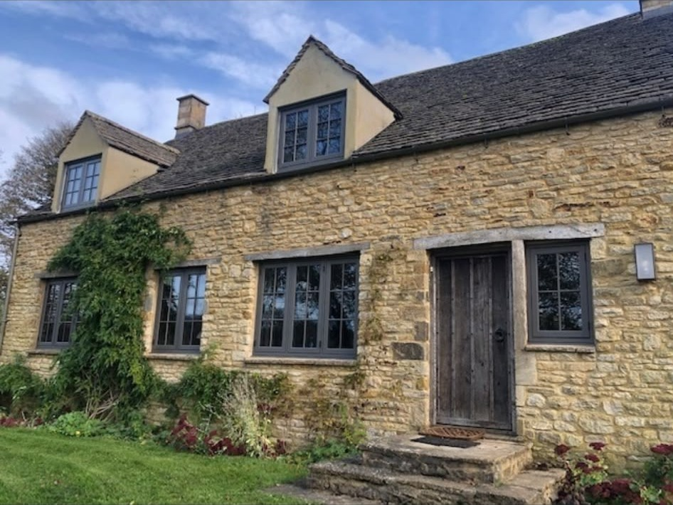 Anthracite grey aluminium-look flush windows fitted to a traditional stone cottage near Chester
